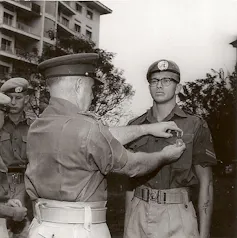 Black and white photo of a man in uniform and a second man pinning a medal on him