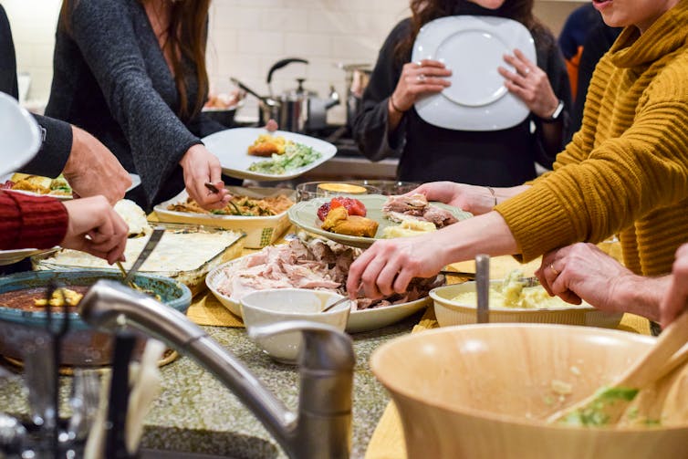 A group of people serving themselves food from a table