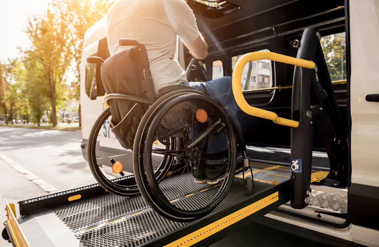 person in wheelchair uses ramp to enter vehicle