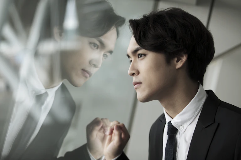 Man looks at his reflection.