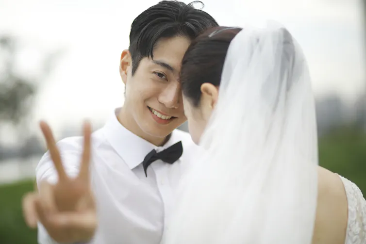 Bridegroom flashes victory sign.
