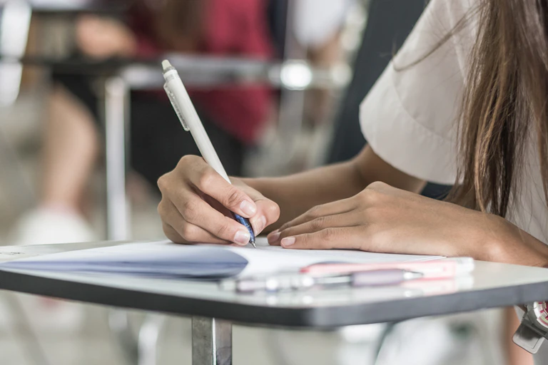 Une candidate qui écrit sur sa copie d'examen