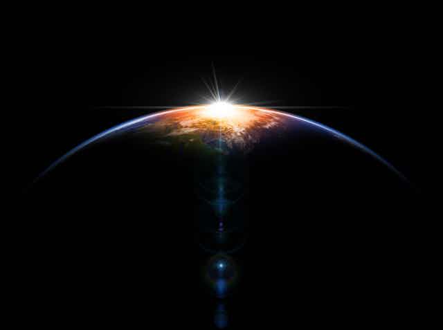 A hemisphere of a planet shown against a bright object in the background