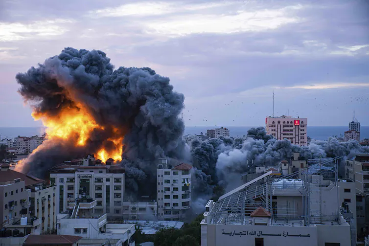 Smoke and flames rising from a building in a city.