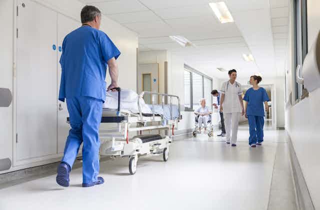 Nurse pushes hospital bed