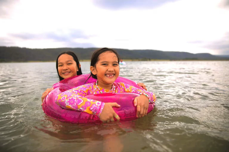 Two girls swim in the river at Penrith Beach