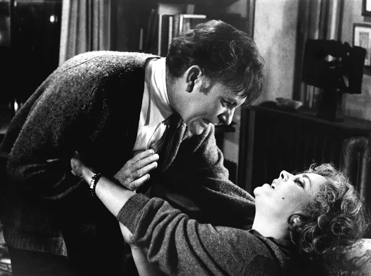 A black and white image of a middle-aged couple fighting.