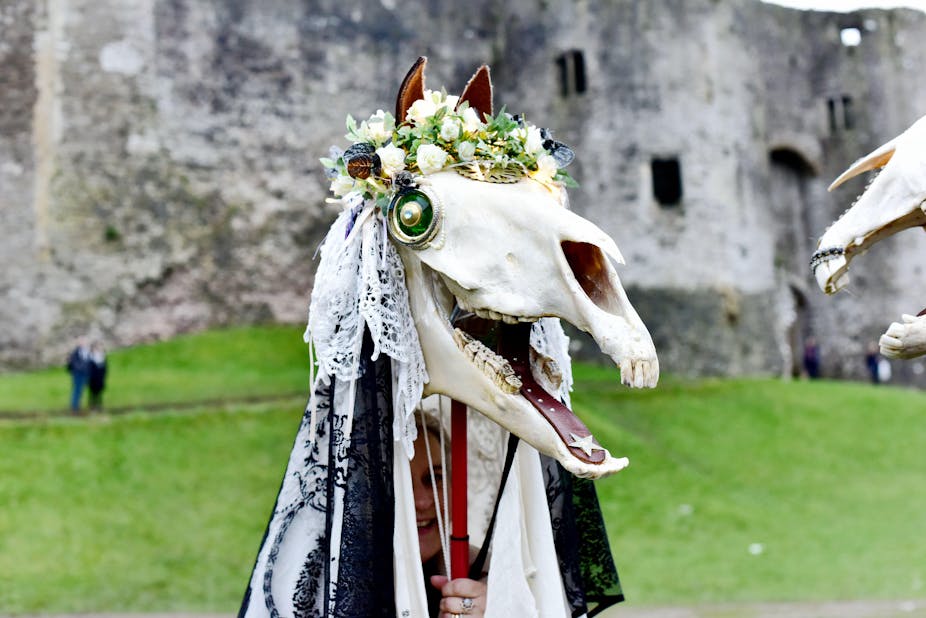 A horse's skull adorned with lace, flowers and buttons.