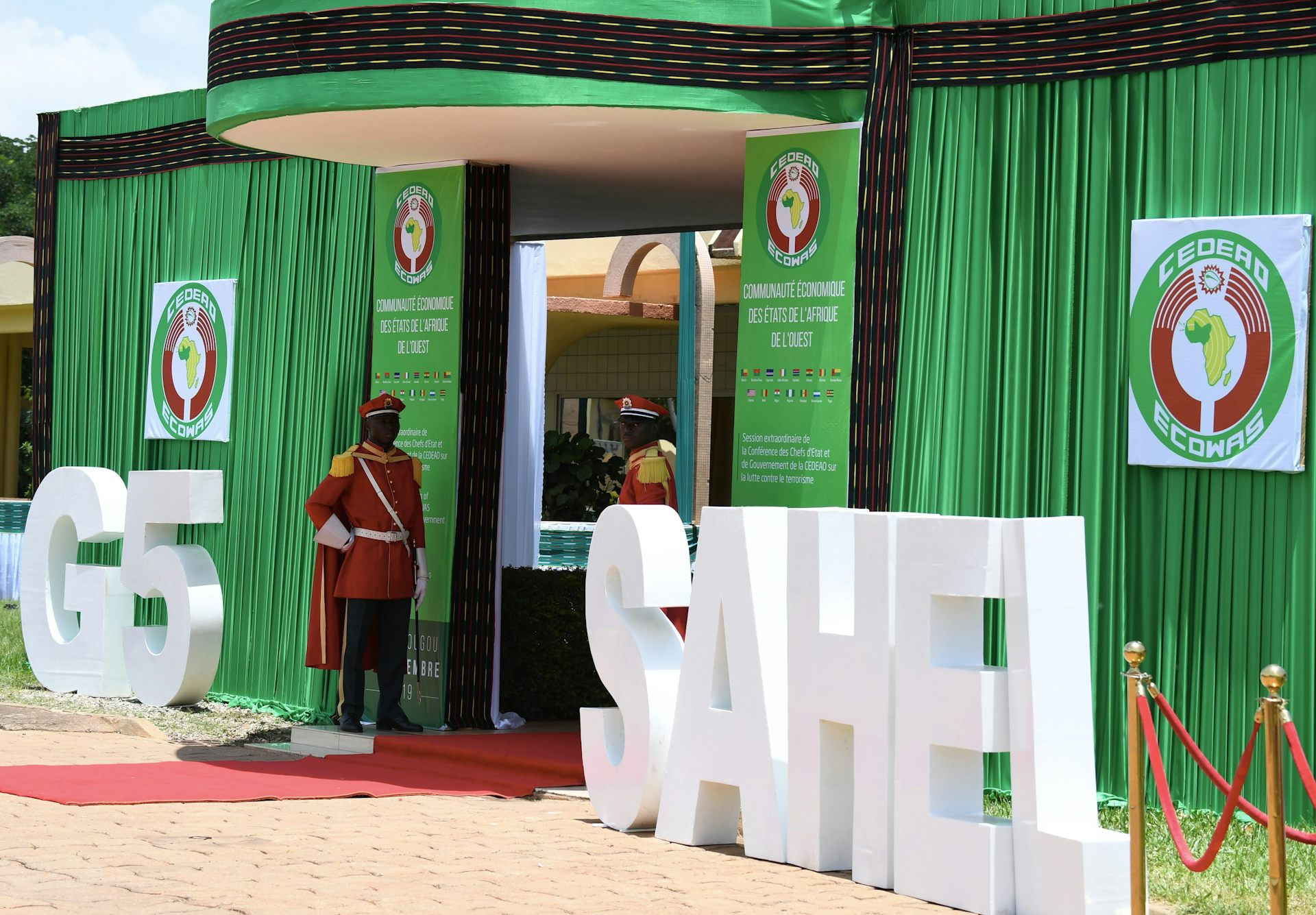 Men in ceremonial military dress stand guard at an entrance