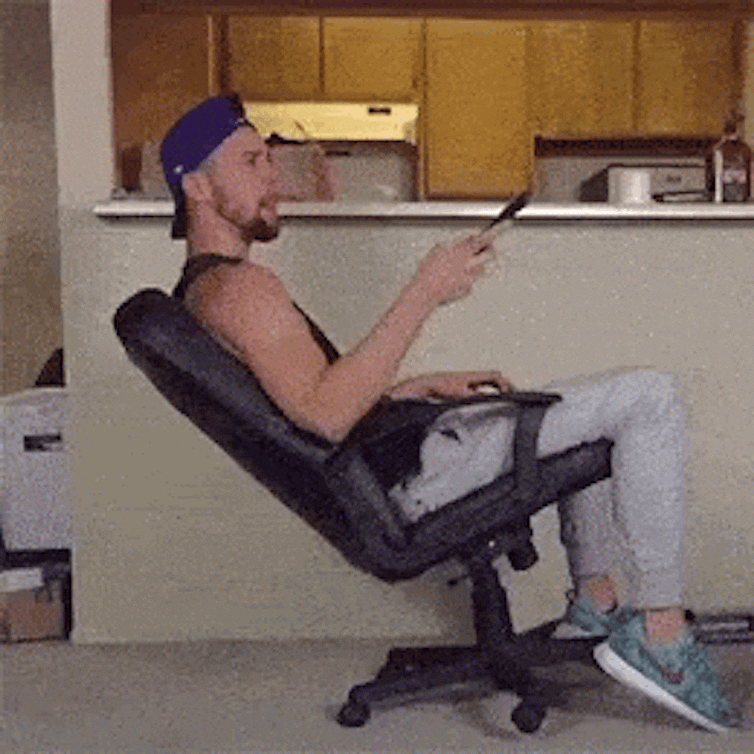 man falls backwards off chair