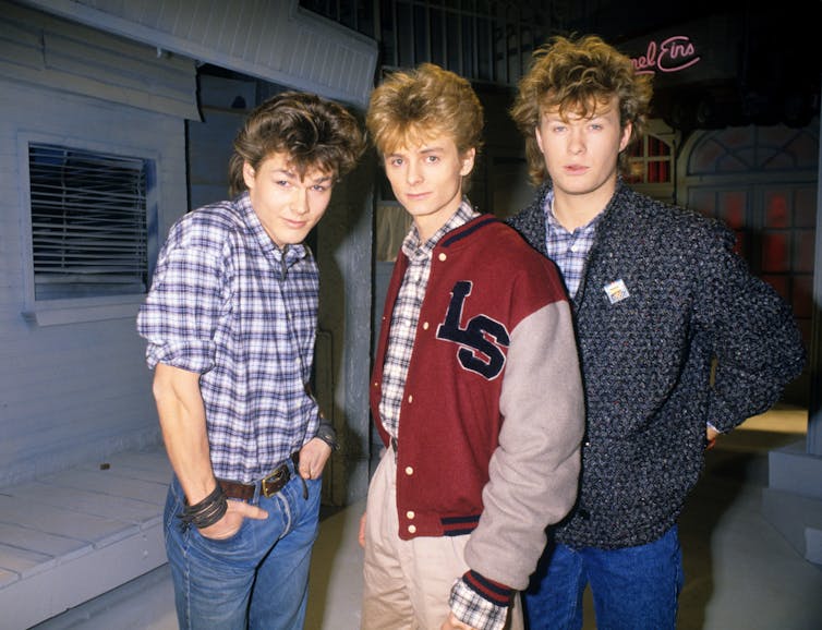 Tres hombres mirando en 1985