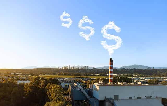 Smokestack with emissions clouds shaped like dollar signs floating into the sky, mountains in the background.