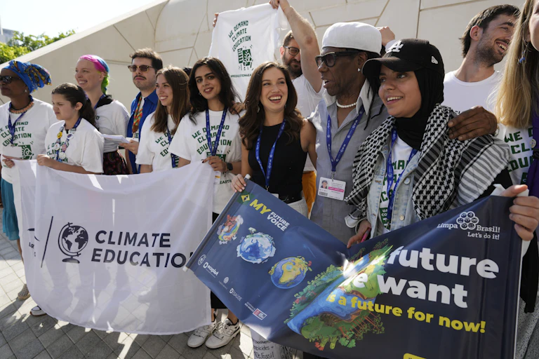 A group of people stand in a row holding signs.