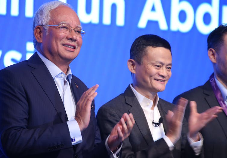 Najib Razak, prime minister of Malaysia, and Jack Ma Yun, founder of Alibaba Group, stand and clap