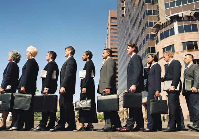 row of business people holding briefcases
