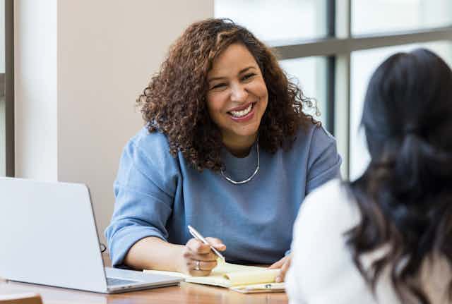 Smiling woman in office with colleague
