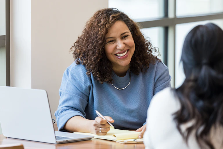 Smiling woman in office with colleague
