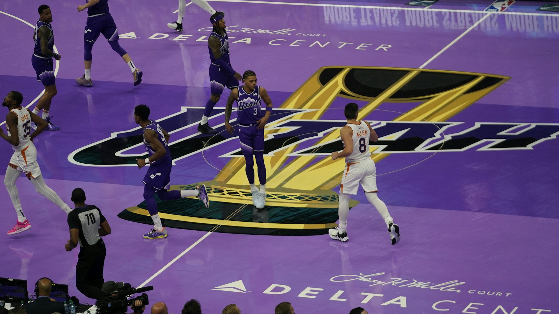Aerial view of basketball players jogging across a purple basketball court
