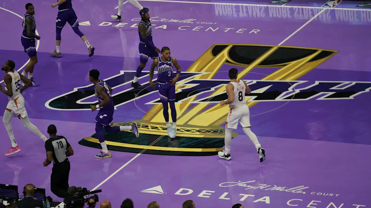 Aerial view of basketball players jogging across a purple basketball court