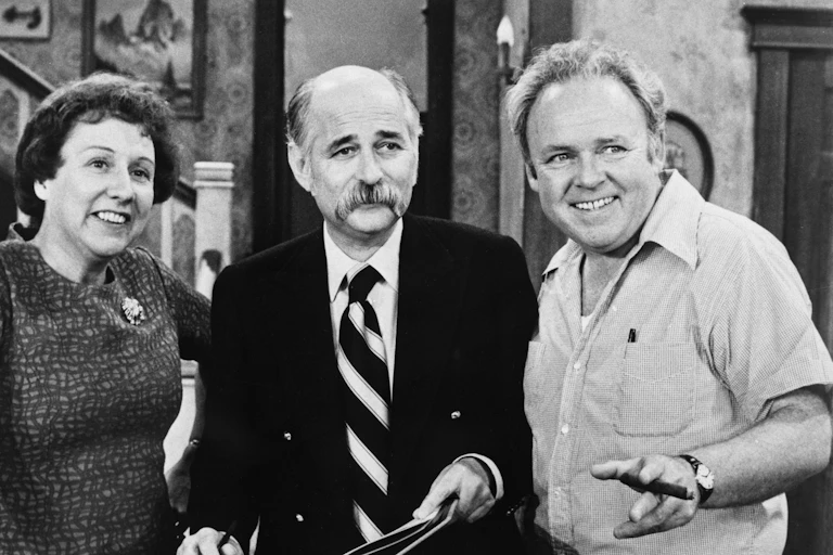 Three people look at the camera in a black and white photo.
