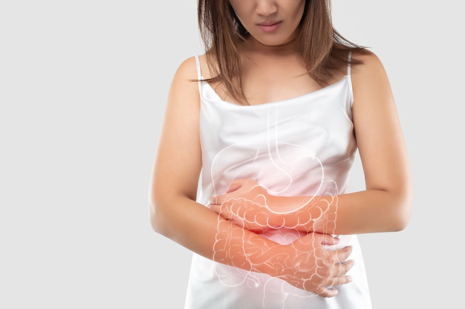 illustration of the intestine and internal organs in a women's body against a grey background