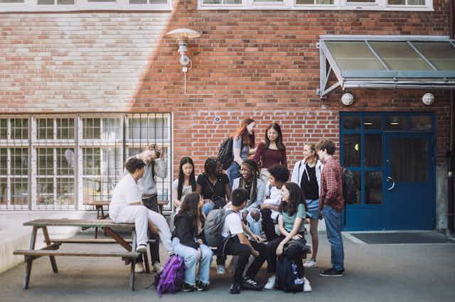 Photo d’un groupe d'adolescents conversant dans la cour d’un établissement.