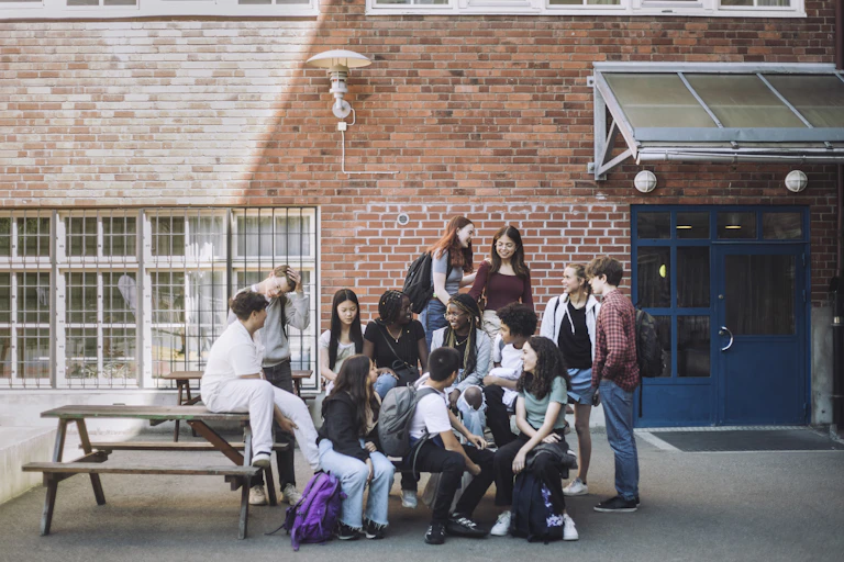 Photo d’un groupe d'adolescents conversant dans la cour d’un établissement.