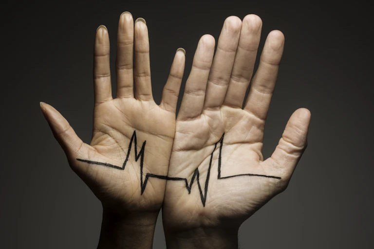 Two hands pressed side by side, connected by an ECG drawing across their open palms