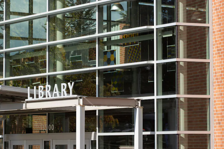 The glass entrance of a library building.