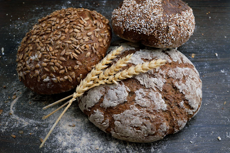 Trois miches de pain et des épis de blé.