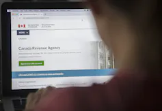 A person looks at the CRA website on their laptop.