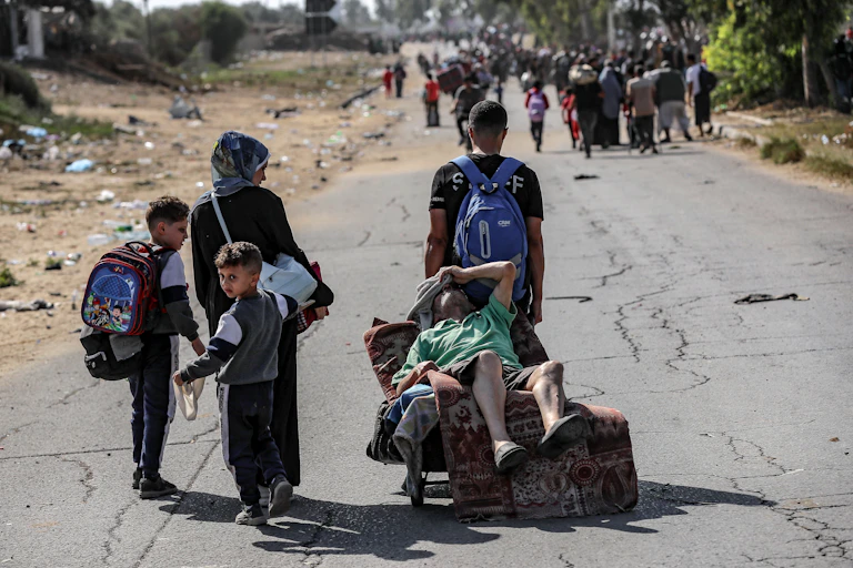 A family carry an injured man along a road.