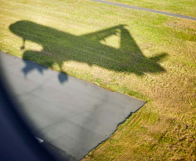 Shadow of airplane cast on grass