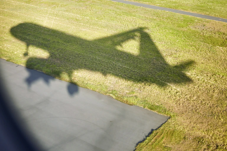 Shadow of airplane cast on grass