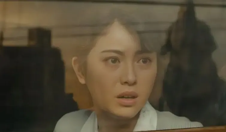 A woman's face seen through a window and a giant lizard is reflected.