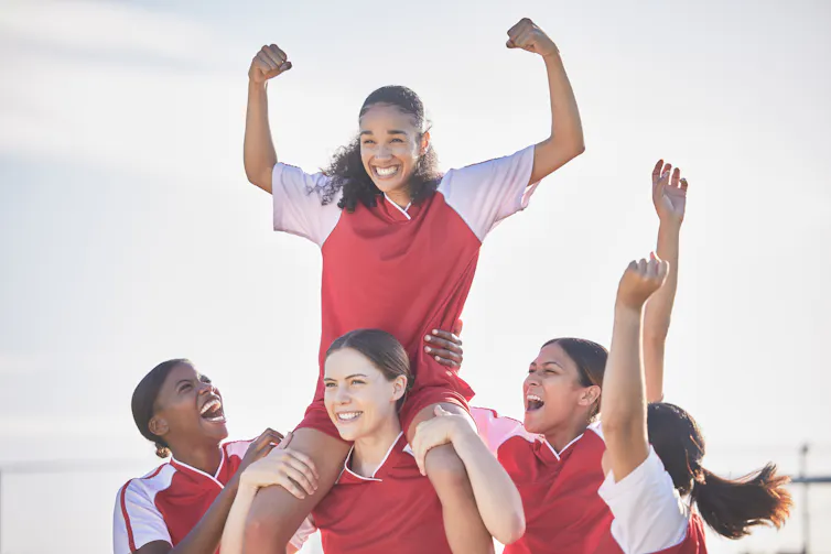 A female soccer team celebrating a goal