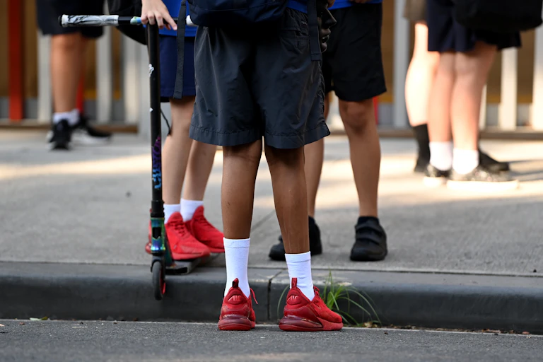 Students wait outside the school gate.