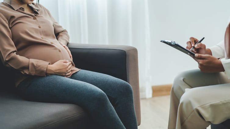 A pregnant woman talks to a therapist.