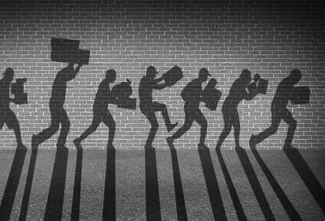 An illustration of shadows against a wall, running with boxes and bags in their arms as if stealing. 