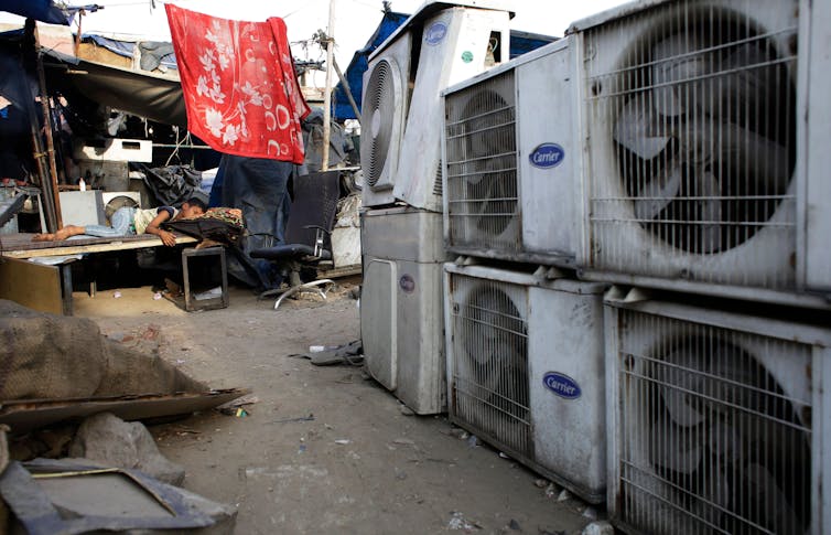 Rows of old air-conditioning units in a marketplace.