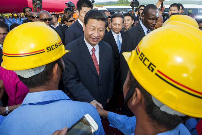 China's President Xi Jinping shakes hands with construction workers