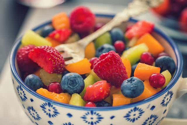 bowl of colorful cut fruit with a fork