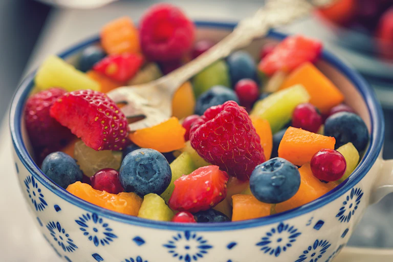 bowl of colorful cut fruit with a fork