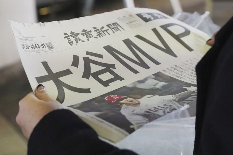 A Japanese newspaper with a photo of a baseball player on the front page