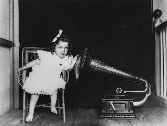 A young girl listening to a gramophone