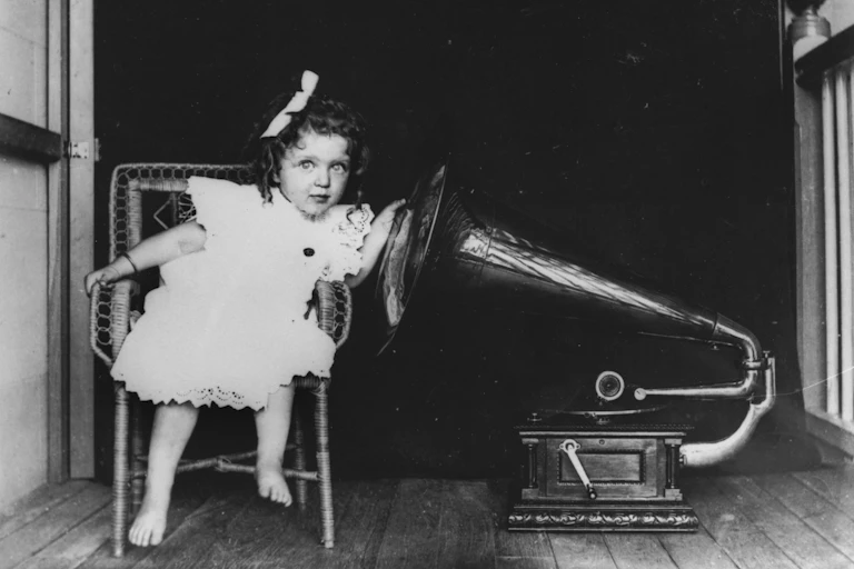 A young girl listening to a gramophone