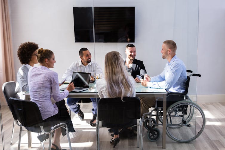 Diverse group of employees sitting around a conference table