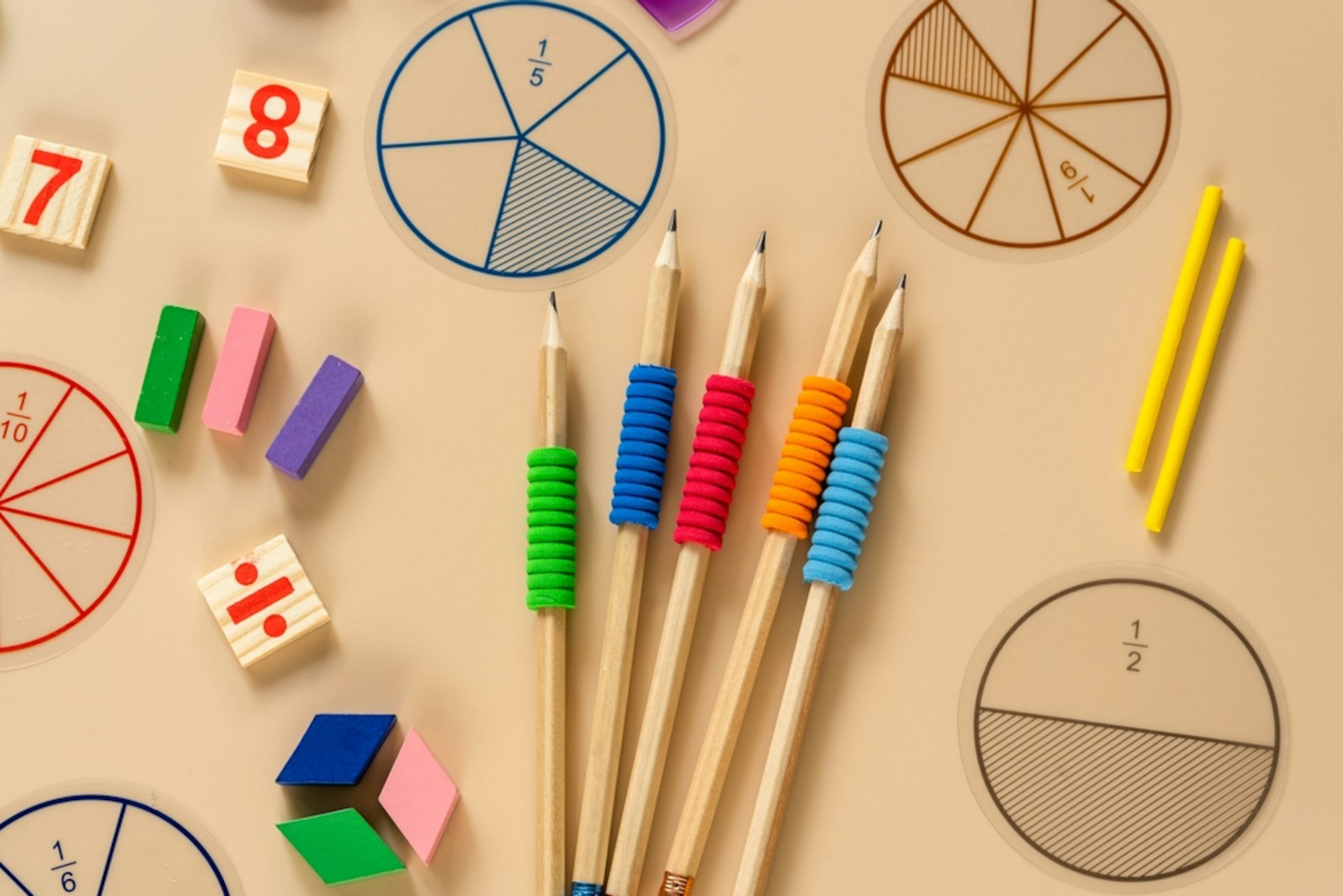 Fournitures scolaires, fractions mathématiques, crayons, nombres, sur fond beige.