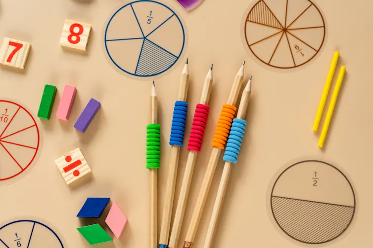 Fournitures scolaires, fractions mathématiques, crayons, nombres, sur fond beige.
