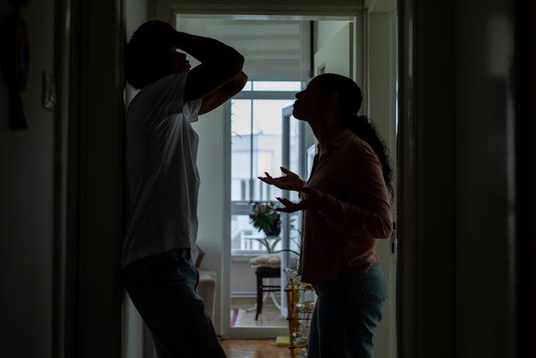 Couple arguing in hallway of home